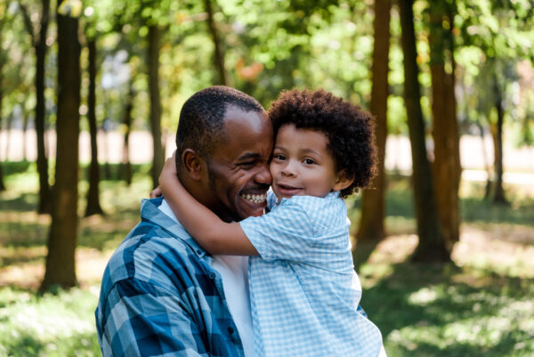 cute african american kid hugging happy father