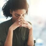 Woman with her hands on her head, looking stressed - decision fatigue