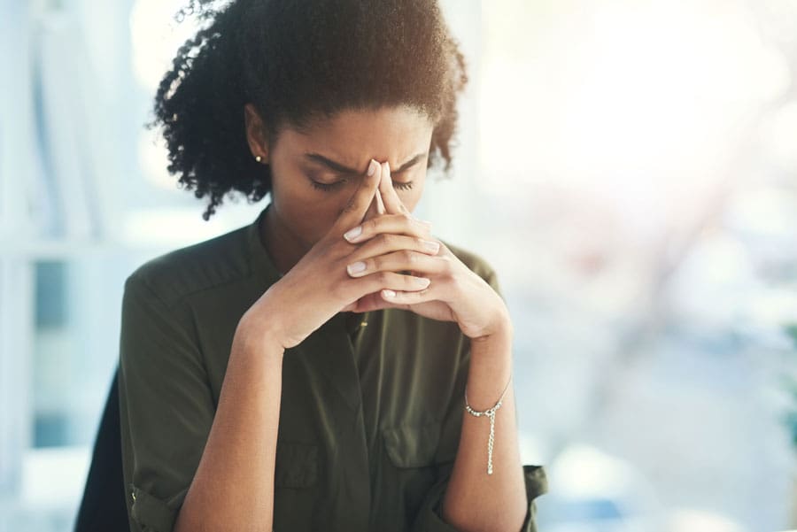 Woman with her hands on her head, looking stressed - decision fatigue