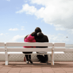 A couple sitting on a bench.